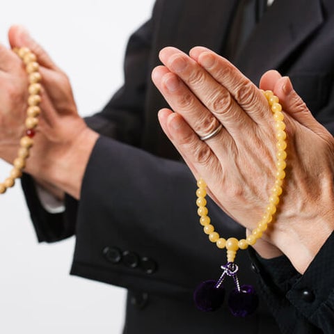 左手に数珠を持ち、お仏壇の前に正座する