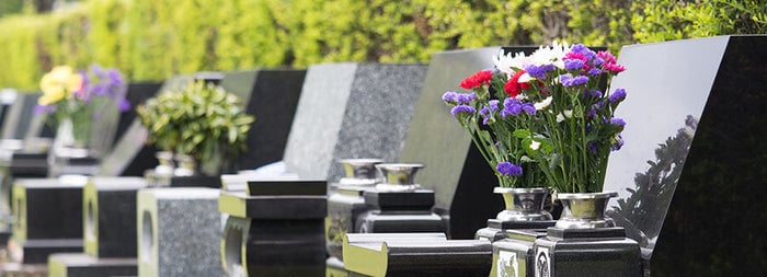 霊園の芝生の上に並んだ墓石