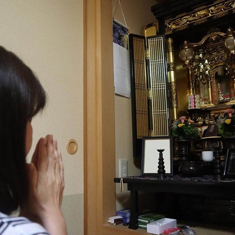 仏前で合掌する女性
