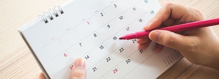 カレンダーをチェックする手元