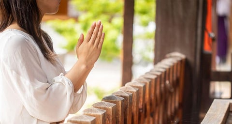 神社で参拝する女性