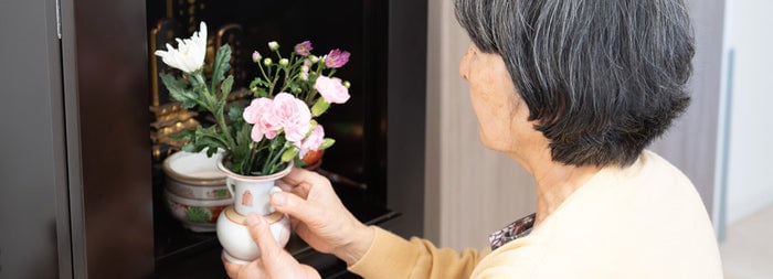 仏壇に花を供える女性